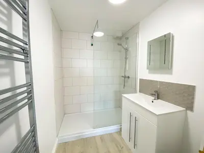 a white bathroom with a sink and a shower at 3 Harvest Moon in Newquay