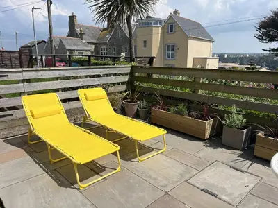 two yellow chairs sitting next to a fence at 3 Harvest Moon in Newquay