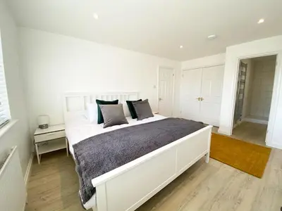 a white bedroom with a large white bed with pillows at 3 Harvest Moon in Newquay