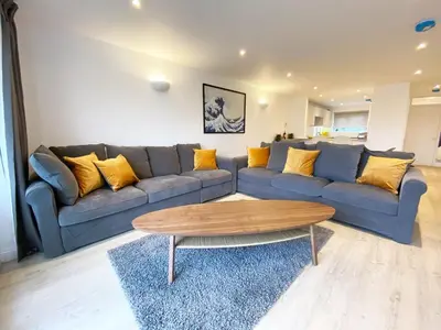 a living room with a blue couch and a coffee table at 3 Harvest Moon in Newquay