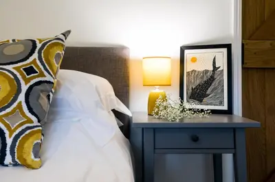 a bedroom with a bed and a nightstand with a lamp at Goose Cottage - within the Helland Barton Farm collection in Delabole