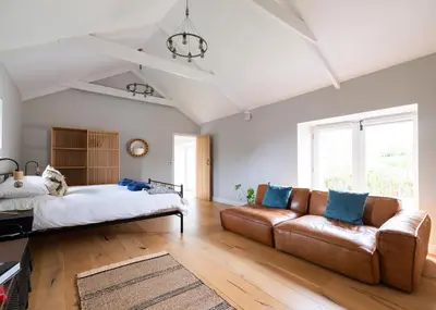 a bedroom with a couch and a bed at The Farmhouse - within the Helland Barton Farm collection in Delabole