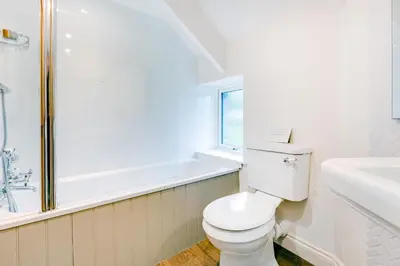 a bathroom with a toilet and a tub and a sink at Courtyard Cottage - within the Helland Barton Farm collection in Delabole