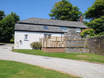 a cottage with a wooden fence in front of it at The Old Bakehouse - within the Helland Barton Farm collection in Delabole