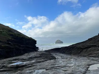 a rocky beach with a mountain in the ocean at The Old Bakehouse - within the Helland Barton Farm collection in Delabole