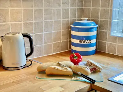 a table with bread and a coffee pot and a plate of food at Heidaway - Padstow in Padstow