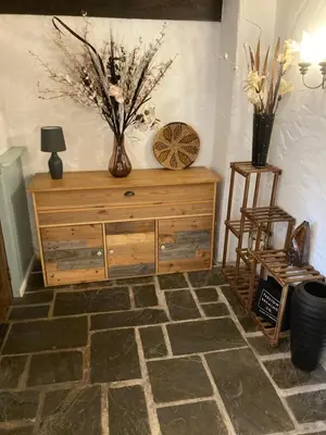 a room with a wooden dresser with flowers on it at Mill Retreat at Bissick Old Mill in Truro
