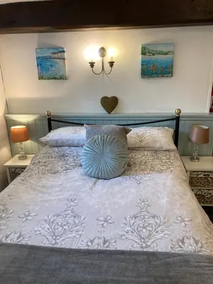 a bed with a white comforter and two lamps at Mill Retreat at Bissick Old Mill in Truro