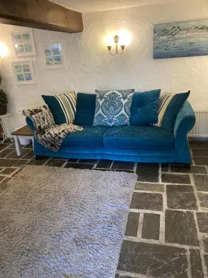 a blue couch sitting in a living room at Mill Retreat at Bissick Old Mill in Truro