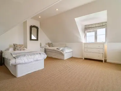 a attic bedroom with two beds and a window at Alpha in Wadebridge
