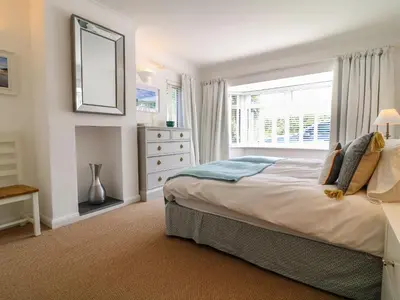 a bedroom with a bed with a window and a dresser at Alpha in Wadebridge