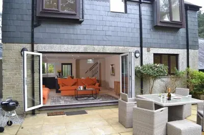 a house with an open patio with an orange couch at Luxury Home on Maenporth Estate Next to the Beach in Falmouth