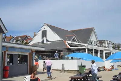 a group of people walking around a building with umbrellas at Luxury Home on Maenporth Estate Next to the Beach in Falmouth