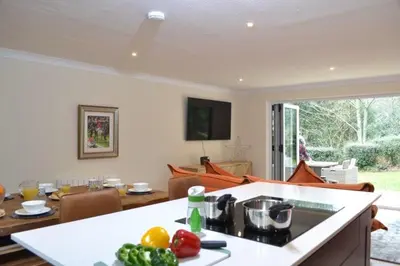 a kitchen and living room with a table with vegetables at Luxury Home on Maenporth Estate Next to the Beach in Falmouth