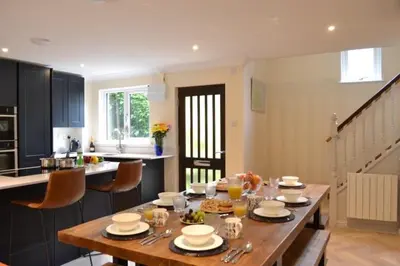 a kitchen with a wooden table with dishes on it at Luxury Home on Maenporth Estate Next to the Beach in Falmouth