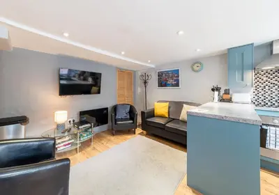 a kitchen and a living room with a couch at Inviting Traditional Fishermens cottage in the heart of the village, close to the harbour in Mevagissey