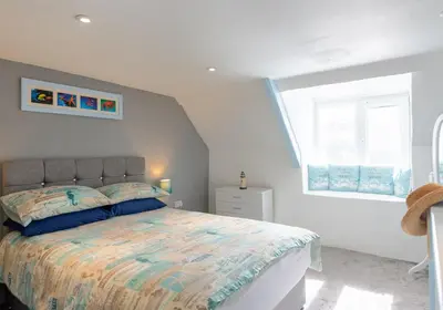 a bedroom with a bed and a window at Inviting Traditional Fishermens cottage in the heart of the village, close to the harbour in Mevagissey