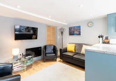 a living room with a couch and a tv at Inviting Traditional Fishermens cottage in the heart of the village, close to the harbour in Mevagissey