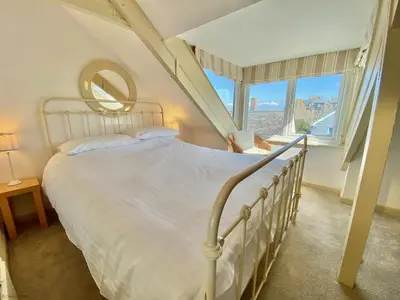 a bedroom with a bed and a large window at Camel Cottage in Padstow