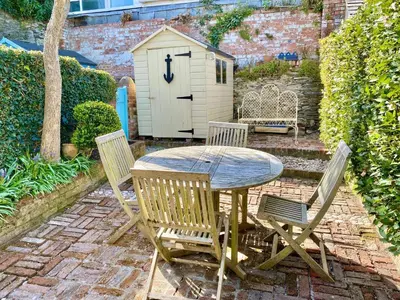 a wooden table and four chairs and a shed at Camel Cottage in Padstow
