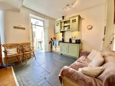 a living room with a couch and a kitchen at Camel Cottage in Padstow