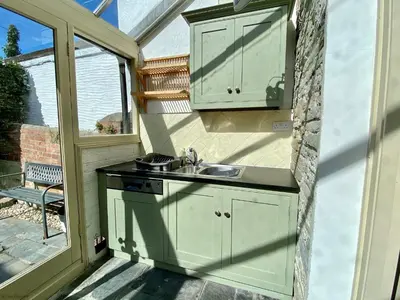 an outdoor kitchen with a sink and a window at Camel Cottage in Padstow