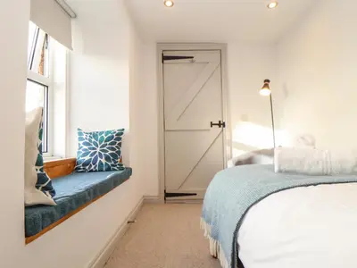 a bedroom with a bed and a sliding door at Ty Bryn in Marazion
