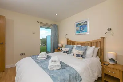 a bedroom with a bed with towels on it at Beach Haven in Carbis Bay