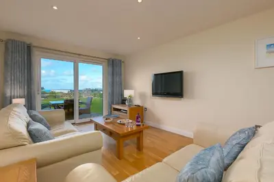 a living room with two couches and a tv at Beach Haven in Carbis Bay
