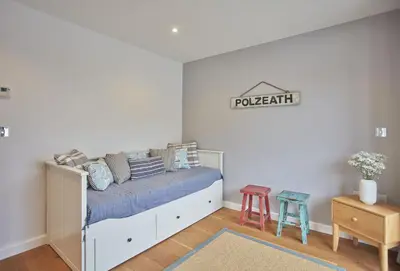 a bedroom with a bed with a sign on the wall at 5 The Sands in Polzeath