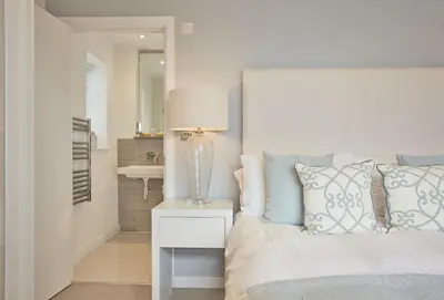 a bedroom with a bed and a lamp on a nightstand at 5 The Sands in Polzeath