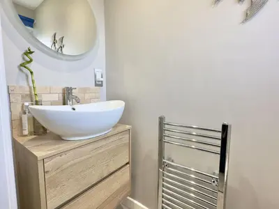 a bathroom with a white sink and a mirror at Curlews, 36 Egerton Road in Padstow