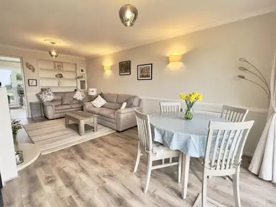 a living room with a table and chairs and a couch at Curlews, 36 Egerton Road in Padstow