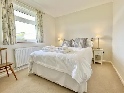 a bedroom with a large white bed with towels on it at Myebon in Padstow