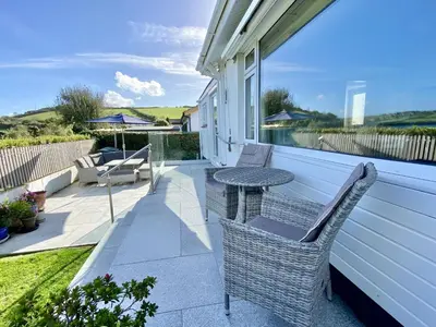a patio with two chairs and a table on a house at Myebon in Padstow