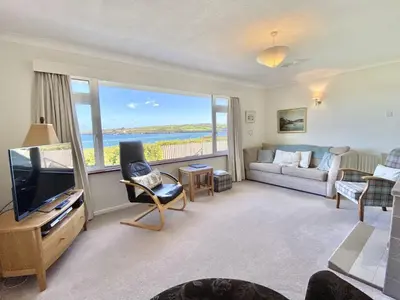 a living room with a couch and a tv and a window at Myebon in Padstow