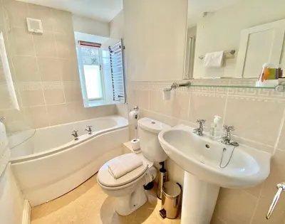 a bathroom with a toilet and a sink and a bath tub at The Cottage in Padstow