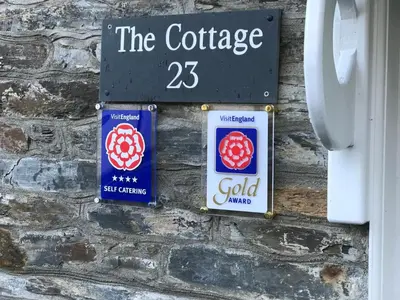a sign on a brick wall with the coffee at The Cottage in Padstow