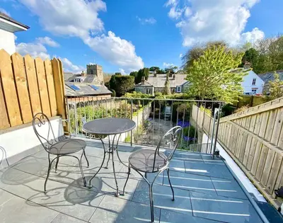 a patio with two chairs and a table on a balcony at The Cottage in Padstow