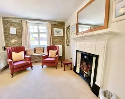 a living room with two chairs and a fireplace at The Cottage in Padstow