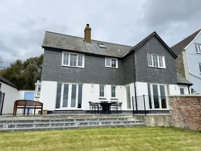 a white house with a table and benches in front of it at Trenaton in Padstow