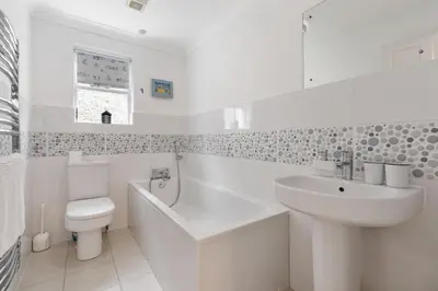 a white bathroom with a sink and a toilet at Trenaton in Padstow