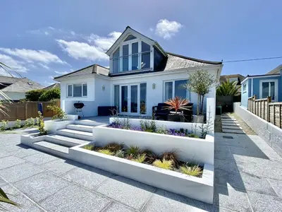a white house with blue windows and plants at Trevillian in Padstow
