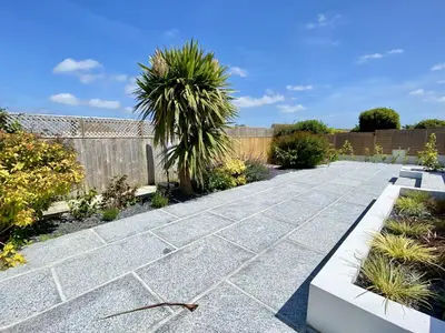 a garden with a stone walkway with palm trees at Trevillian in Padstow