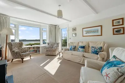 a living room with a couch and chairs and a window at Aeolian in Padstow
