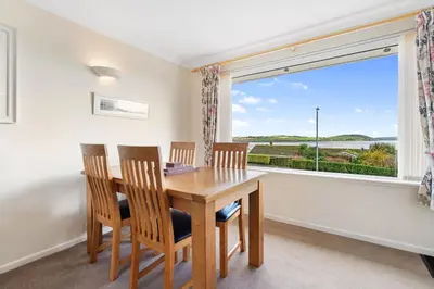 a dining room with a table and chairs and a large window at Gwel Teg, 30 Egerton Road in Padstow