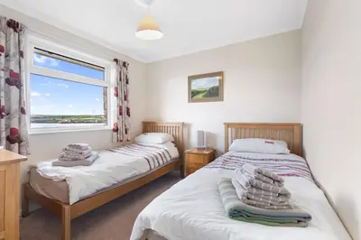 two beds in a bedroom with a window at Gwel Teg, 30 Egerton Road in Padstow