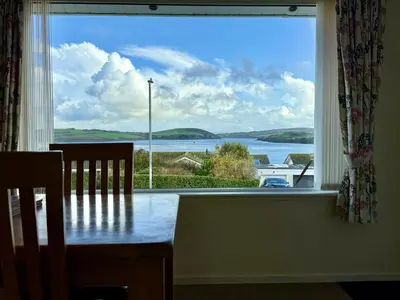 a dining room with a table and a large window at Gwel Teg, 30 Egerton Road in Padstow
