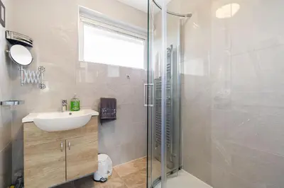 a bathroom with a glass shower and a sink at Gwel Teg, 30 Egerton Road in Padstow