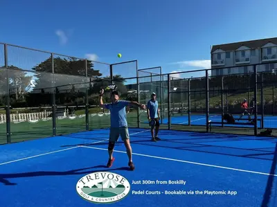two men playing tennis on a tennis court at Boskilly in St Merryn